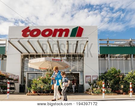FRANKFURT GERMANY - JUN 30 2017: Mother and child walking to the entrance of TOOM the German DIY-store chain offering home improvement and do-it-yourself goods - customers buying goods selecting the best tools