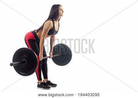 Young athletic brunette woman doing deadlift with barbell on white isolated background side view half-bent position