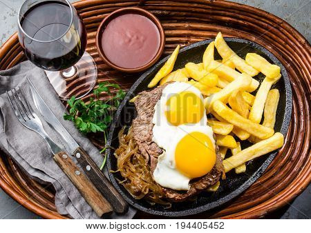 Peruvian Latin American food. Lomo a lo pobre. Beef whit fried potatoes french fry and egg served with chile sauce and wine
