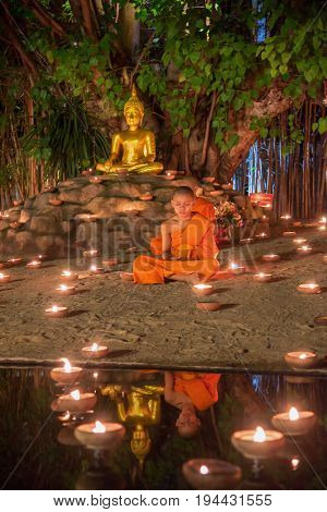 CHIANG MAI THAILAND - JULY 08 2017 :Unidentified monks in ritual around Buddha statue among many candlelight at Phan Tao temple Chiang maiThailand in Asanha Puja Day