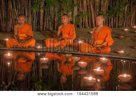 CHIANG MAI THAILAND - JULY 08 2017 :Unidentified monks in ritual around Buddha statue among many candlelight at Phan Tao temple Chiang maiThailand in Asanha Puja Day