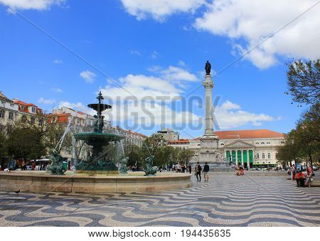 Rossio Square (Praca Dom Pedro IV) in Lisbon, Portugal. Popular meeting and hang out place for locals and tourists. Summer colorful brght wallpaper.