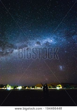 Couple  Pointing To The Galaxy At The Sky.  Milky Way Over Sesriem Camping Site, Namibia.