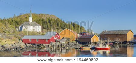 Moskenes on the Lofoten in northern Norway. The Typical Norwegian fishing village of Moskenes under midnight sun, blue sky, with the typical rorbu houses. 
