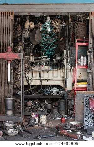 Old dirty Autoshop with lots of tools in front