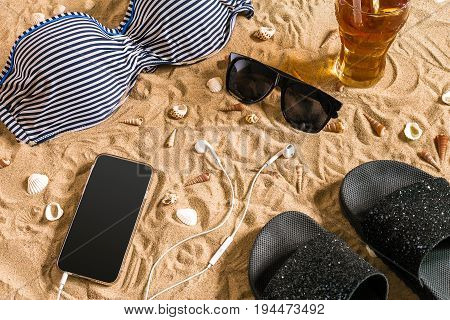 Summer bikini and accessories stylish beach set, Beach bikini summer outfit and sea sand as background, Top View, Concept. Copy space