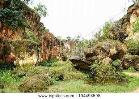 The exploitation of limestone hills canyon forming a unique architectural in Arosbaya Hill Madura Island, Indonesia