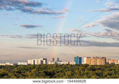 Rainbow In Evening Sky Over Residential Houses