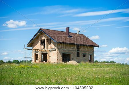 Brick House construction site. Building construction ceramic brick house. Unfinished Home Construction with roof.