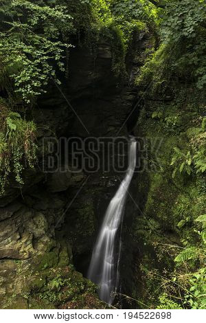Beautiful Flowing Waterfall With Magical Fairytale Feel In Lush Green Forest Location