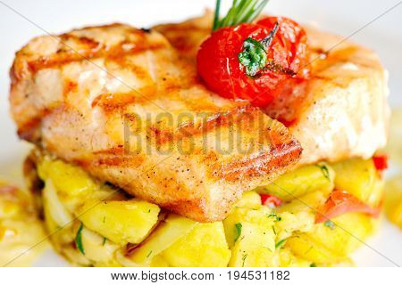 Grilled salmon closeup with potetos and green onions