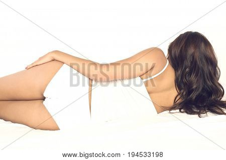 Rear view of a young woman lying in bed