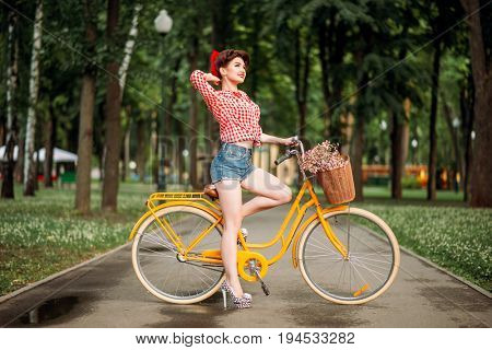 Pin-up girl on bicycle, vintage american fashion