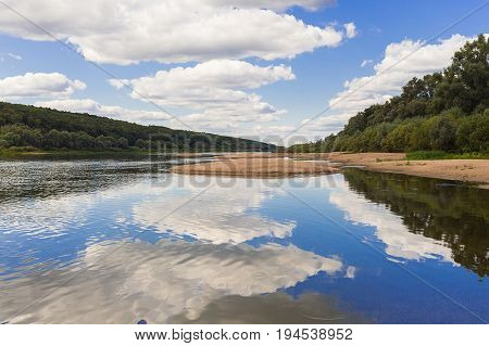Sand island among the calm surface of the river along the banks of the forest rest relaxation in a sunny day