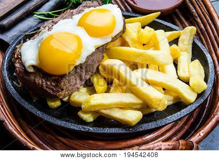 Peruvian Latin American food. Lomo a lo pobre. Beef whit fried potatoes french fry and egg served with chile sauce and wine