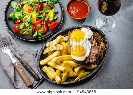 Peruvian Latin American food. Lomo a lo pobre. Beef whit fried potatoes french fry and eggs