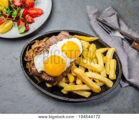 Peruvian Latin American food. Lomo a lo pobre. Beef whit fried potatoes french fry and eggs