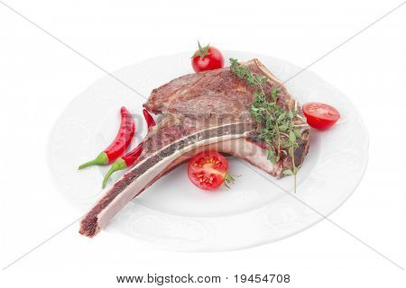 cibo di carne: manzo alla griglia di ricambio rib su piatto bianco con timo pepe e pomodoro isolato sopra bianca ba