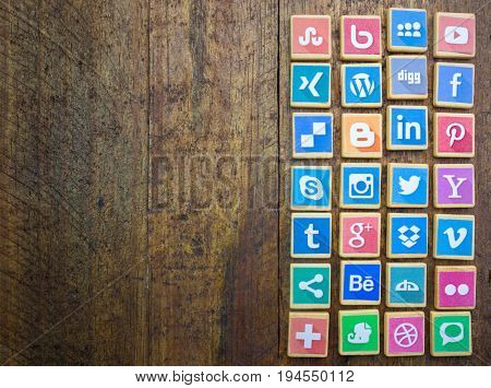 QUEENSTOWN SOUTH AFRICA - 09 APRIL 2017: Social Media logotype popular collection printed and place on wood scrabble game pieces isolated on rustic brown wooden floor planks