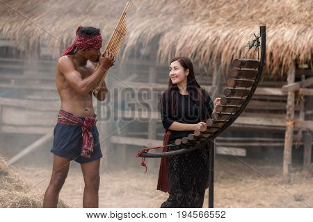 Asian beautiful girl are happy playing Pong Lang is a Thai musical instrument in summer at Countryside.