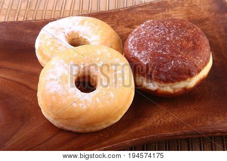 Assorted Homemade Doughnuts with Jelly filled and powdered sugar on wooden salver. Selective focus
