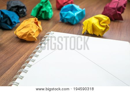 Open Blank Ring Binder White Book  With Group Of Colorful Crumpled Paper Ball On Dark Brown Table To
