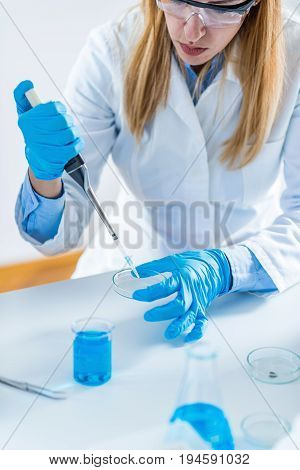 Laboratory technician with micro pipette tone dimage one woman