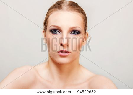 Attractive blonde topless woman with dark eye make up