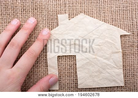 Hand Holding A Paper House On Canvas