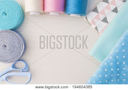 Sewing kit. Thread blue, pink, beige, cloth fabric, scissors,rolls ribana grey and menthol