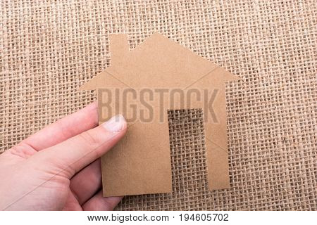 Hand Holding A Paper House On Canvas