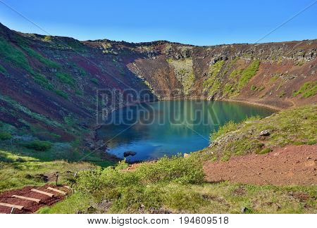 View into the Kerid crater with its blue lake at the bottom as a part of the famous Golden Circle in western Iceland