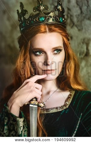 Portrait of a beautiful red-haired woman in green medieval dress