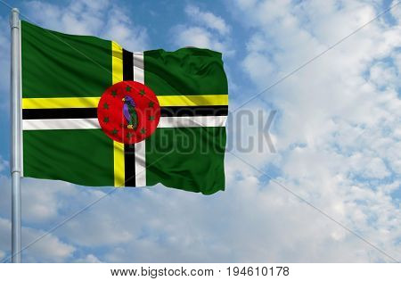 National flag of Dominica on a flagpole in front of blue sky.
