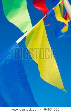 Dangling in the wind festive flags on the background of blue sky