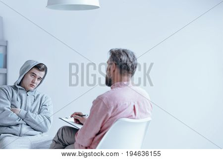 Troubled teenager having an individual session with a therapist