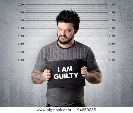 Caugth offender in front of a wall with table in his hand.