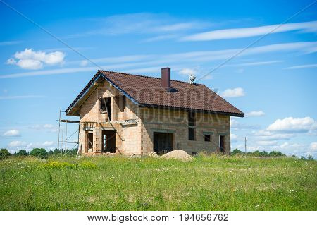 Brick House construction site. Building construction ceramic brick house. Unfinished Home Construction with roof.