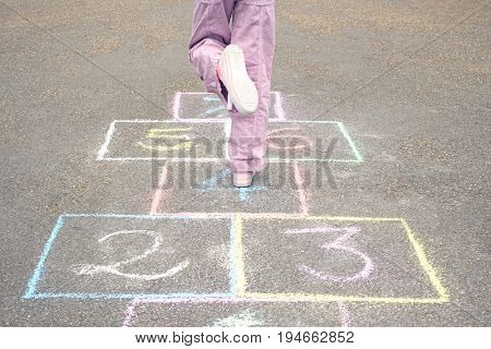 Low section of girl playing hop-scotch in playground