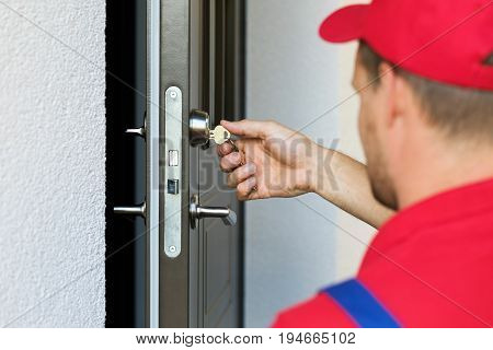 door lock service - locksmith working in red uniform