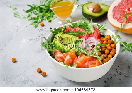 Healthy salad bowl with salmon grapefruit spicy chickpeas avocado red onion and arugula. Delicious balanced food concept