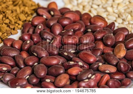 Dried red seeds of beans close-up in set of groceries. Food product background with limited depth of field.