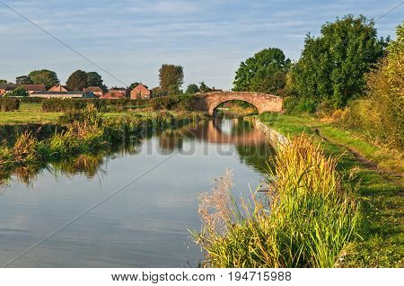 Peaceful Canal and Tow Path with Small Brick Bridge