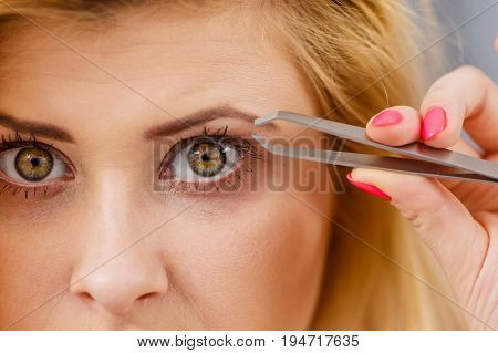 Woman Tweezing Eyebrows Depilating With Tweezers