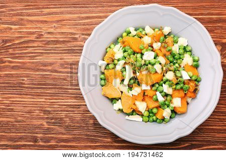 Warm salad with roasted pumpkin, peas and cheese brie. Low fat healthy eating concept.