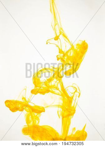Ink swirl in a water on white background. The paint splash in the water. Soft dissemination a droplets of colored ink in water close-up. Abstract background. Explosion of color splashes acrylic ink.