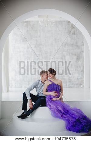 pregnant woman and man posing together in Studio, happy waiting