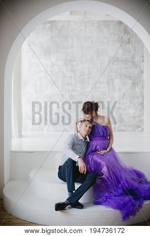 pregnant woman and man posing together in Studio, happy waiting