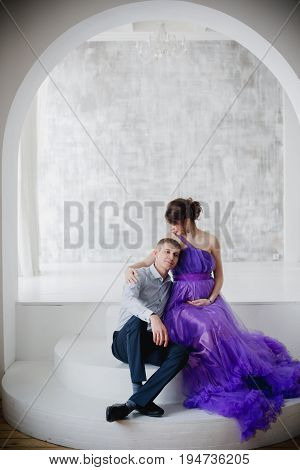 pregnant woman and man posing together in Studio, happy waiting