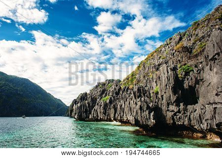 El Nido Palawan Philippines. Sharp rocks in lagoon. Blue sky with clouds and clear sea water.